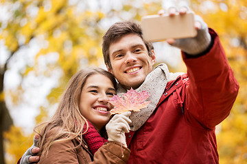 Image showing couple taking selfie by smartphone in autumn park