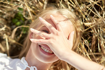 Image showing happy young woman lying on cereal field