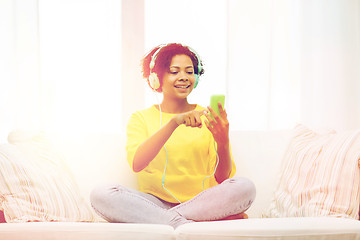 Image showing happy african woman with smartphone and headphones