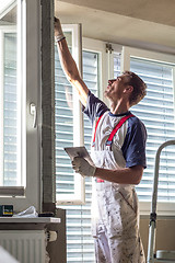 Image showing Plasterer renovating indoor walls and ceilings. Finishing works.