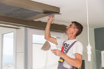 Image showing Plasterer renovating indoor walls and ceilings. Finishing works.