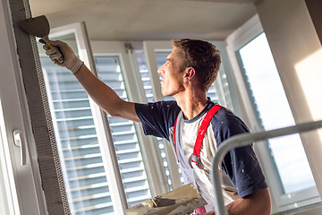 Image showing Plasterer renovating indoor walls and ceilings. Finishing works.