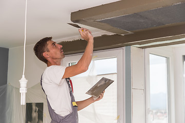 Image showing Plasterer renovating indoor walls and ceilings. Finishing works.