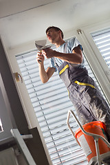 Image showing Plasterer renovating indoor walls and ceilings. Finishing works.