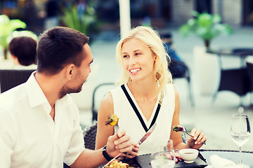 Image showing happy couple eating dinner at restaurant terrace