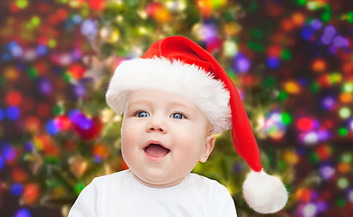 Image showing baby boy in christmas santa hat over blue lights