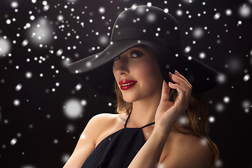 Image showing beautiful woman in black hat over snow