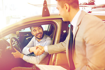 Image showing happy man with car dealer in auto show or salon