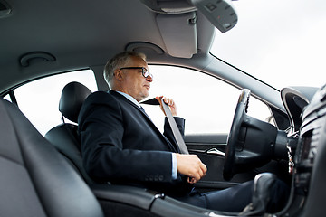 Image showing senior businessman fastening car seat belt