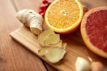 Image showing citrus fruits, ginger and garlic on wood