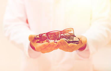 Image showing close up of optician with glasses at optics store