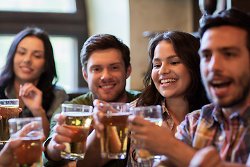 Image showing happy friends drinking beer at bar or pub