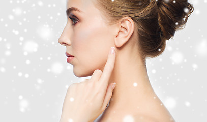 Image showing close up of woman pointing finger to ear over snow