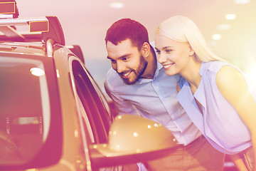 Image showing happy couple buying car in auto show or salon