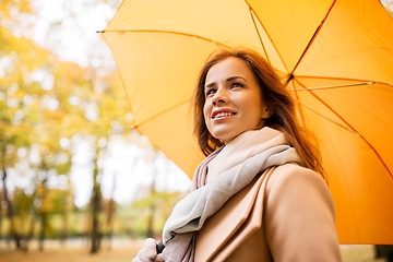 Image showing happy woman with umbrella walking in autumn park