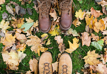 Image showing couple of feet in boots and autumn leaves