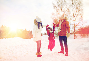 Image showing happy family in winter clothes walking outdoors