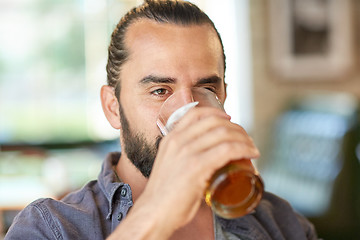 Image showing close up of man drinking beer at bar or pub