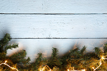 Image showing Wooden white texture background with christmas fir tree and lightbulb