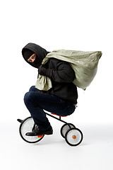 Image showing Thief in mask on bicycle