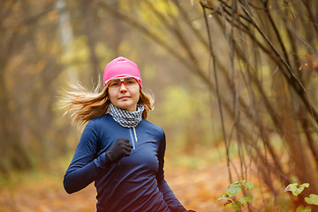 Image showing Young sporty woman doing Jogging in autumn forest