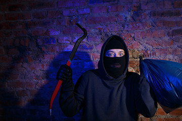 Image showing Night gangster near brick wall