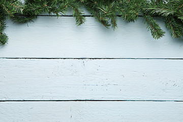 Image showing Spruce branch on white wooden surface. New year, Christmas background