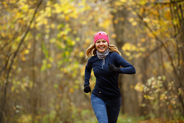 Image showing Girl in sneakers among leaves