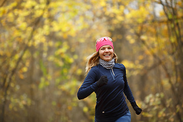 Image showing Woman in sneakers among leaves