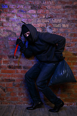 Image showing Robber near wall of building