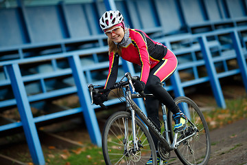 Image showing Outdoors portrait of woman cyclist sitting on sports bicycle