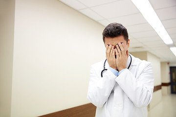 Image showing sad or crying male doctor at hospital corridor
