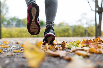 Image showing close up of young woman running in autumn park