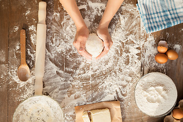 Image showing Female cooking dough. View from above.