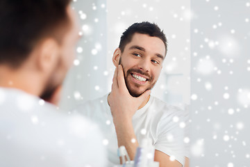 Image showing happy young man looking to mirror at home bathroom