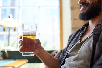 Image showing close up of happy man drinking beer at bar or pub