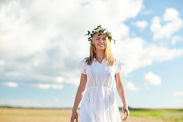 Image showing smiling young woman in wreath of flowers outdoors