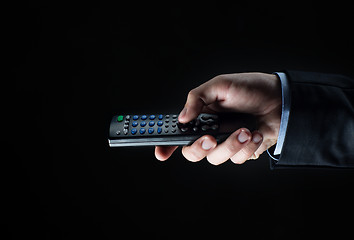 Image showing close up of businessman hand with remote control