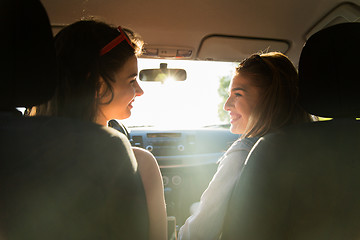 Image showing happy teenage girls or women driving in car