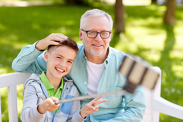 Image showing old man and boy taking selfie by smartphone