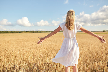 Image showing happy young woman in white dress on cereal field