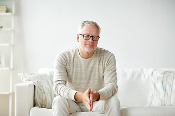 Image showing smiling senior man in glasses sitting on sofa