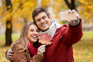 Image showing couple taking selfie by smartphone in autumn park