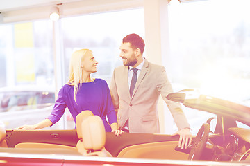 Image showing happy couple buying car in auto show or salon