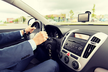 Image showing close up of young man in suit driving car