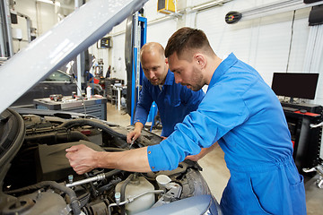 Image showing mechanic men with wrench repairing car at workshop