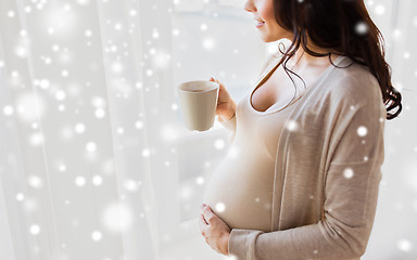 Image showing close up of pregnant woman with tea cup at window