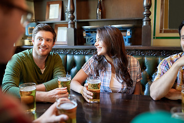 Image showing happy friends drinking beer at bar or pub