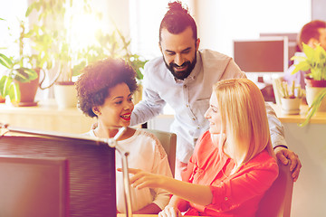 Image showing happy creative team with computer in office