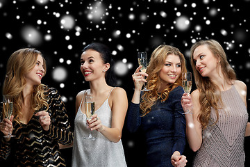 Image showing happy women with champagne glasses over snow